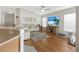 Bright and airy living room with wood floors, a sectional sofa, and an entertainment center under a large tv at 3412 Trapnell Ridge Dr, Plant City, FL 33567