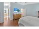 Spacious main bedroom with wood floors, television, and ensuite bathroom at 3412 Trapnell Ridge Dr, Plant City, FL 33567