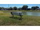 Scenic view of a community pond with a bench, offering a relaxing spot to enjoy the outdoors and neighborhood views at 3412 Trapnell Ridge Dr, Plant City, FL 33567