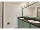 Updated bathroom with double sinks, dark countertops, green cabinets, and a shower stall at 3455 Overland Dr, Holiday, FL 34691