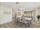 Bright dining room with a modern white table, pendant lighting, and access to a kitchen and outdoor area at 3455 Overland Dr, Holiday, FL 34691