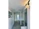 Bright hallway with grey wood floors, sleek mirror and an adjacent room with white walls at 3455 Overland Dr, Holiday, FL 34691