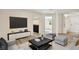 Well-lit living room featuring stylish furniture, light colored floors, and an open entryway at 3455 Overland Dr, Holiday, FL 34691