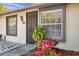 Home featuring a black secured front door, updated windows, and garden with colorful impatiens at 3970 La Costa Ln, Largo, FL 33771