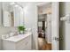 Well-lit bathroom featuring white vanity and a view into an adjacent bedroom with an open doorway at 4415 Black Fox Dr, New Port Richey, FL 34653