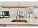 Kitchen island with stainless steel sink, gooseneck faucet, quartz counters, in an open layout to living and dining areas at 4415 Black Fox Dr, New Port Richey, FL 34653