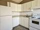 Kitchen with white cabinets, countertop, refrigerator and white appliances at 514 Brandon Ave, Clearwater, FL 33765