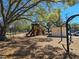 Community playground area with swings, a slide, and play structure under a shade tree at 514 Brandon Ave, Clearwater, FL 33765
