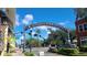A vibrant city street with a 'Defending Freedom' monument, shops, palm trees, and a clear blue sky at 514 Brandon Ave, Clearwater, FL 33765