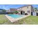 A refreshing backyard pool is surrounded by greenery and a covered patio with a hot tub at 5916 Tulip Flower Dr, Riverview, FL 33578