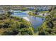 Aerial view of a community with a serene lake, and winding path surrounded by trees and tropical landscaping at 6447 Cypressdale Dr # 202, Riverview, FL 33578