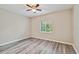 Bright bedroom features neutral walls, wood-look floors, window with blinds, and ceiling fan at 6447 Cypressdale Dr # 202, Riverview, FL 33578