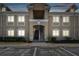 Two-story condo building with beige facade and well-lit windows at dusk at 6447 Cypressdale Dr # 202, Riverview, FL 33578