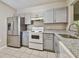 Kitchen featuring stainless steel refrigerator, stove, and granite countertops at 6447 Cypressdale Dr # 202, Riverview, FL 33578