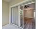 View from the sliding glass doors out to balcony and into the living room with hardwood floors and ceiling fan at 6447 Cypressdale Dr # 202, Riverview, FL 33578