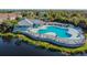 Aerial view of a community pool, clubhouse, and a picturesque lake, enhancing the community's appeal at 6447 Cypressdale Dr # 202, Riverview, FL 33578