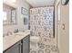 Bathroom with gray vanity, patterned tile floor, shower with flower curtain and light gray walls at 703 June Lake Ln, Brandon, FL 33510