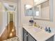 Bathroom with a light countertop, gray cabinets, hardwood floors, and a framed mirror at 703 June Lake Ln, Brandon, FL 33510