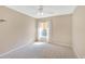 Bedroom with a ceiling fan, neutral carpet and walls and a large window for natural light at 703 June Lake Ln, Brandon, FL 33510