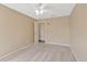 Bedroom with beige walls, ceiling fan, and light carpet, featuring an interior door at 703 June Lake Ln, Brandon, FL 33510