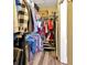 Walk-in closet with wooden floors, storage shelves, hanging clothes and personal items at 703 June Lake Ln, Brandon, FL 33510