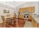 Bright kitchen with wood cabinets, stainless steel appliances, and a cozy dining area at 703 June Lake Ln, Brandon, FL 33510
