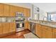 Kitchen area with hardwood floors, stainless steel appliances, and wooden cabinets at 703 June Lake Ln, Brandon, FL 33510