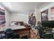 A cluttered bedroom featuring hardwood flooring, poster, and unpainted walls at 7143 Sealawn Dr, Spring Hill, FL 34606