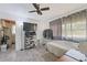 This bedroom has a ceiling fan, hard flooring, and a rack for holding clothes and shoes at 7143 Sealawn Dr, Spring Hill, FL 34606