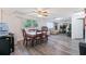 Open-concept dining area featuring modern laminate flooring, a ceiling fan, and bright natural light at 7143 Sealawn Dr, Spring Hill, FL 34606