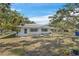 Exterior view featuring white exterior, decorative shutters, tidy landscaping, lawn and shady trees at 7143 Sealawn Dr, Spring Hill, FL 34606