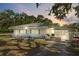 Charming single-story home featuring a carport, brick accents, and well-maintained landscaping under a picturesque sunset at 7143 Sealawn Dr, Spring Hill, FL 34606