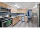 Modern kitchen with stainless steel appliances, granite countertops, and sleek wooden cabinetry at 7143 Sealawn Dr, Spring Hill, FL 34606