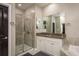 Well-lit bathroom with a tiled walk-in shower, granite countertops, and white cabinets at 8766 Capstone Ranch Dr, New Port Richey, FL 34655