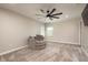 Neutral bedroom with a unique swivel chair, ceiling fan, and two bright windows at 8766 Capstone Ranch Dr, New Port Richey, FL 34655