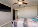 Bright bedroom with nautical comforter and pillowcases, ceiling fan, and mounted TV at 8766 Capstone Ranch Dr, New Port Richey, FL 34655