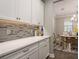 Stylish butler pantry with white cabinets, quartz countertops, and decorative backsplash at 8766 Capstone Ranch Dr, New Port Richey, FL 34655