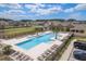 An aerial shot of a sparkling community pool featuring lounge chairs and green spaces at 8766 Capstone Ranch Dr, New Port Richey, FL 34655