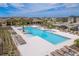 Community pool with multiple lounge chairs and tables for relaxation and socializing by the water at 8766 Capstone Ranch Dr, New Port Richey, FL 34655
