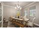 Elegant dining room features a chandelier and a rustic farmhouse table with seating for six at 8766 Capstone Ranch Dr, New Port Richey, FL 34655