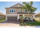 Inviting two-story home with lush landscaping and covered front porch, perfect for enjoying the outdoors at 8766 Capstone Ranch Dr, New Port Richey, FL 34655