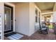 Cozy front porch with rocking chairs and brick flooring creates a welcoming entrance at 8766 Capstone Ranch Dr, New Port Richey, FL 34655