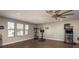 Spacious game room with arcade games, exercise equipment, ceiling fan, and large windows at 8766 Capstone Ranch Dr, New Port Richey, FL 34655