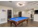 Bright game room featuring a blue billiard table, dark trim, and a modern light fixture at 8766 Capstone Ranch Dr, New Port Richey, FL 34655