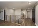 Upstairs hallway with hardwood floors, modern railing, and natural light at 8766 Capstone Ranch Dr, New Port Richey, FL 34655