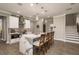 Bright kitchen with marble waterfall island with sink and pendant lights and four counter-height chairs at 8766 Capstone Ranch Dr, New Port Richey, FL 34655