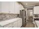 Modern kitchen featuring quartz countertops, white cabinets, and stainless steel appliances at 8766 Capstone Ranch Dr, New Port Richey, FL 34655