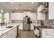 Bright white kitchen featuring stainless steel appliances, tile backsplash and wood grain tile flooring at 8766 Capstone Ranch Dr, New Port Richey, FL 34655