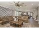 Open-plan living area showcases a decorative accent wall, large sectional sofa and kitchen in background at 8766 Capstone Ranch Dr, New Port Richey, FL 34655
