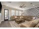 Spacious living room with a large sectional sofa, decorative wall and door to outdoor pool at 8766 Capstone Ranch Dr, New Port Richey, FL 34655